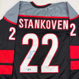 Autographed/Signed Logan Stankoven Carolina Black Hockey Jersey Beckett BAS COA